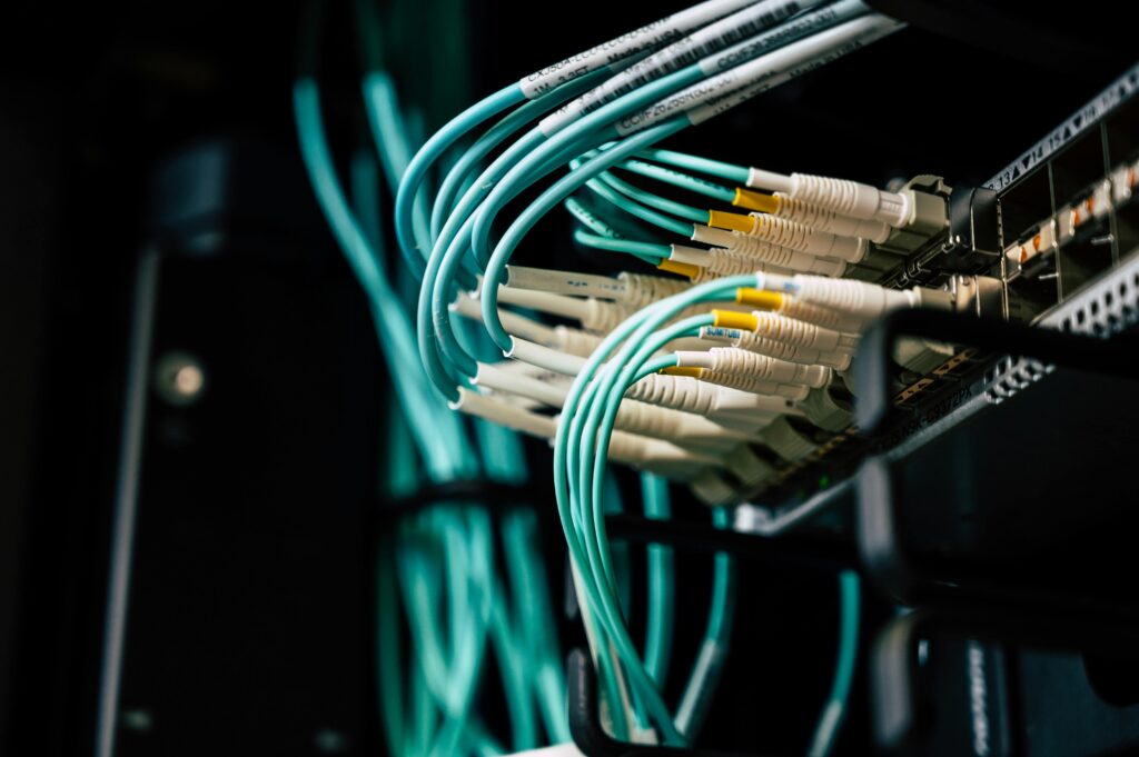 Detailed view of network cables plugged into a server rack in a data center.